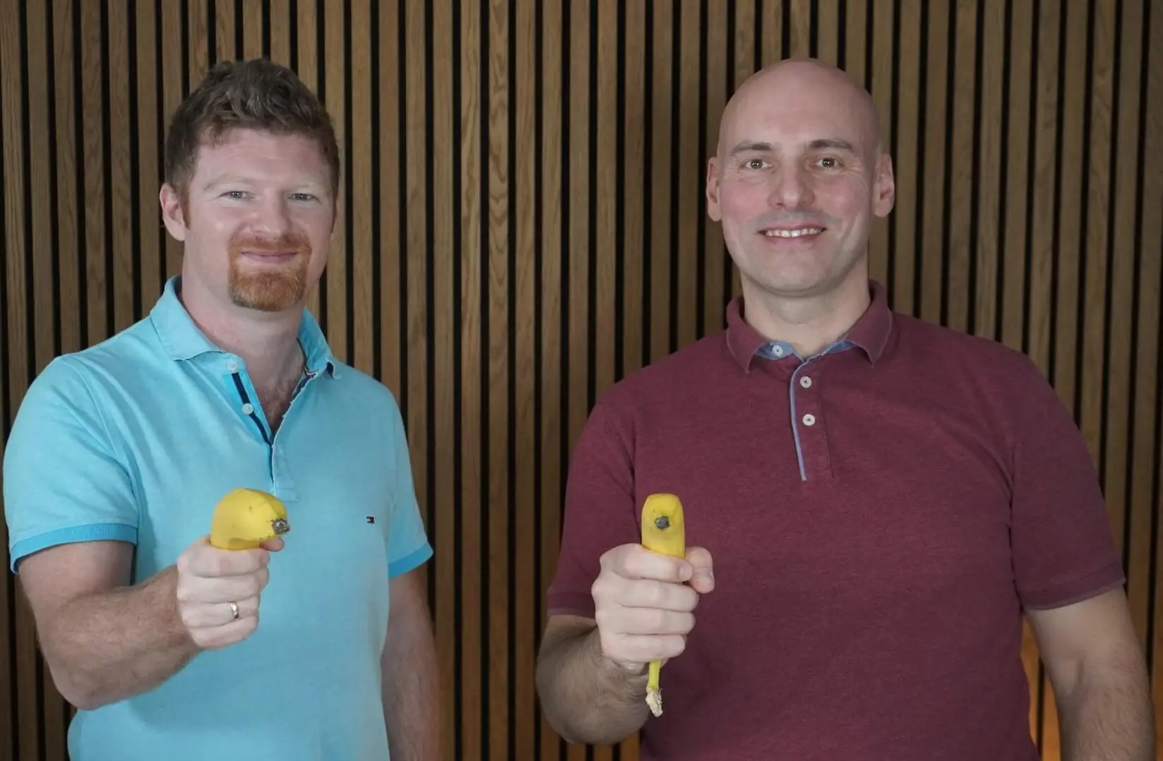 Andreas und Florian von Banana Marketing aus Oberösterreich lachen und halten als Marketing-Gag jeder eine Banane wie einen Revolver in der Hand